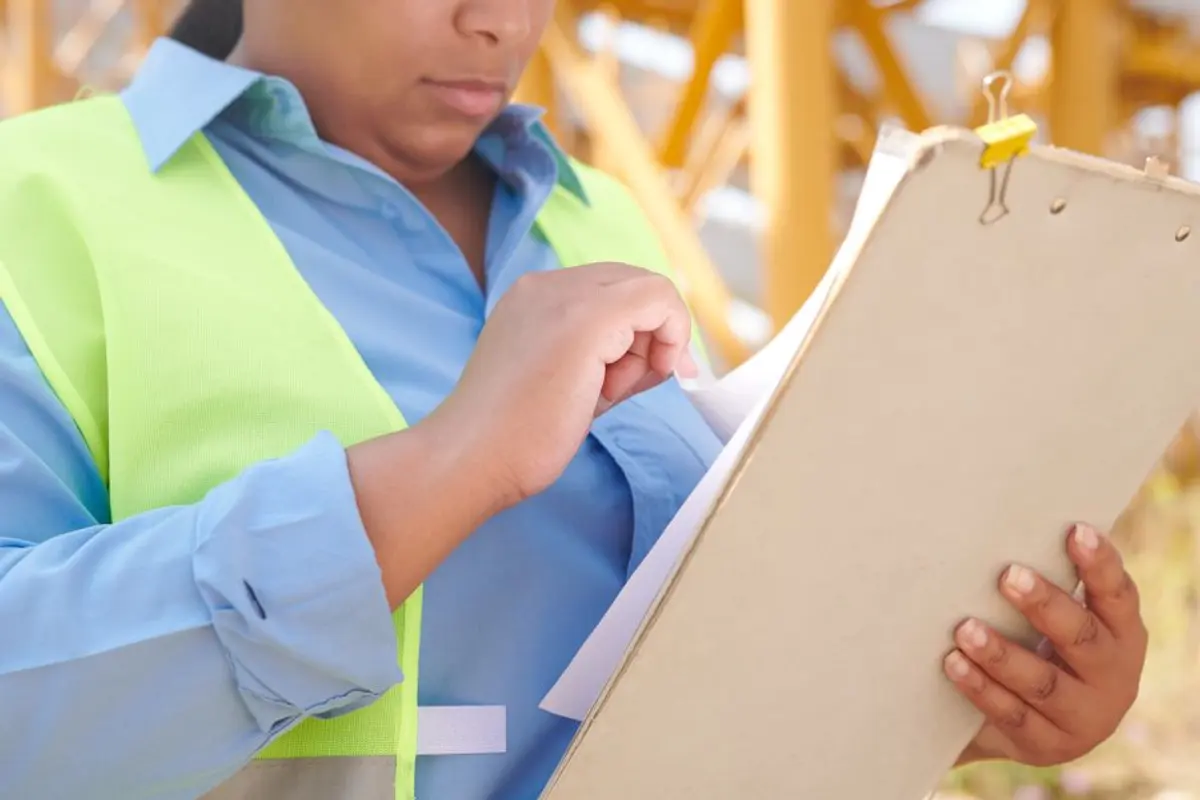 Artisan et expert examinant les fissures d'un mur après réception de chantier